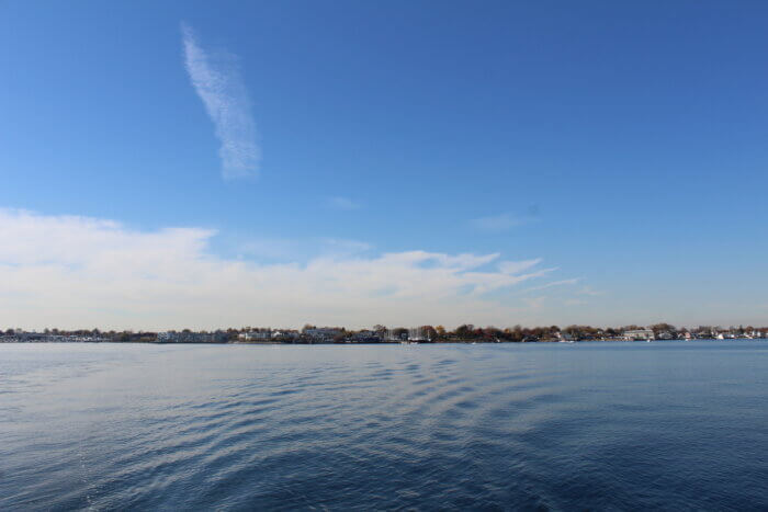 The ferry leaves City Island across the water in the distance.