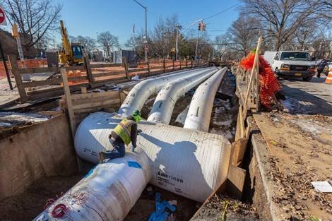 Pelham Parkway North Service Road between Esplanade and Williamsbridge Road. The 48-inch trunk water main was reduced to three smaller pipes, called a manifold, to accommodate the underground subway station. Photo and caption courtesy DDC