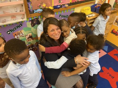 Eileen Torres is embraced by a group of local children supported by the social services offered at BronxWorks.
