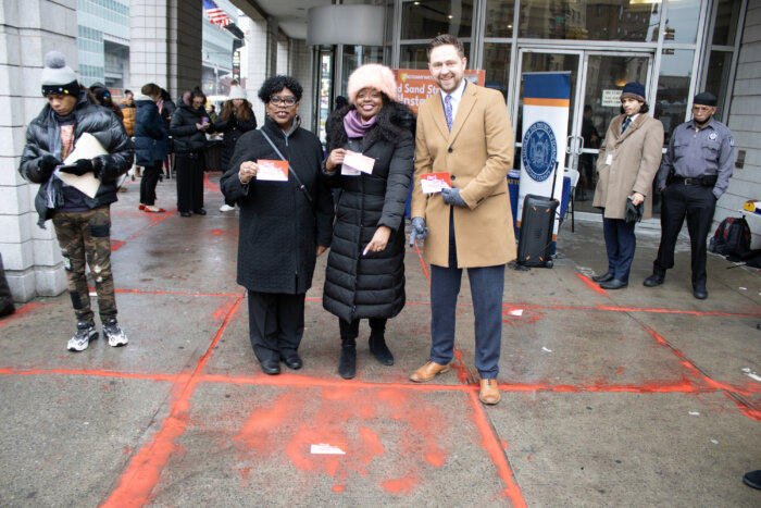 Holding the Red Sand Project posters and pointing at the art on the floor by attendees is (l-r) Bronx County District Attorney, Darcel Clark; Pamela Damon, Executive Director at Not On My Watch, Inc. and Stephen Knoepfler, Chief of the Human Trafficking Unit Special Victims Division in the front of the Office of the Bronx County District Attorney.