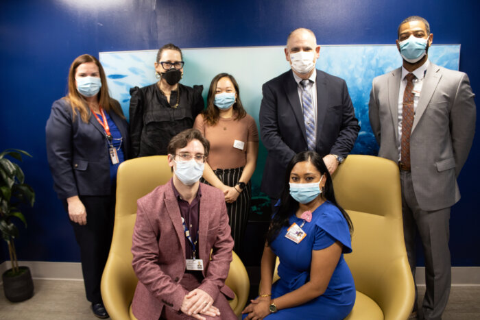 A group photo inside the Employee Wellness Room with (l-r, front) Jeremy Segall, assistant vice president; Alisha Bronne; (back) Joanne Sampson, chief human resources officer; Julie Torres Moskovitz, architect; Katherine Hui, designer; Christopher Mastromano, chief executive officer and Alfredo Jones, deputy executive director.