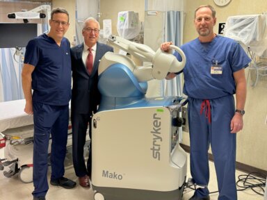 L-R: David Lent, MD, FAAOS; Michael Spicer, President & CEO; Eric Spencer, MD, FAAOS, with Surgical Robot