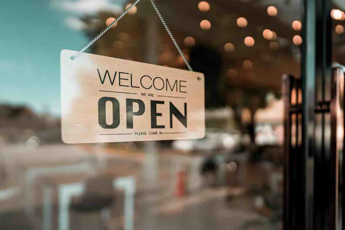 Open cafe or restaurant. Open sign board on glass door in modern cafe coffee shop