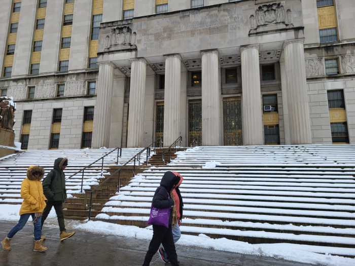 People walk by a Bronx Borough Hall covered in snow on Tuesday, Feb. 13, 2024.