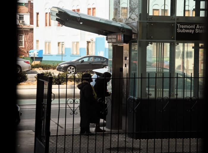 Two people board the new elevator from the street to the Tremont Avenue subway station.