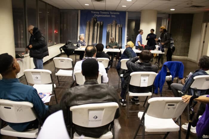Community members converse and organize after the meeting has come to an end.