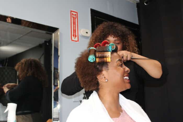 Kerene Edie sits with rollers in her hair in Van Nest on Tuesday, Feb. 20, 2024.