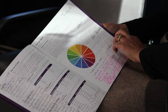 Denisse Uribe Palin pulls out some of her class workbooks at her salon in Van Nest on Tuesday, Feb. 20, 2024.