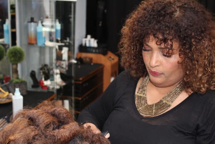 Denisse Uribe Palin styles a client's hair at her salon in Van Nest on Tuesday, Feb. 20, 2024.