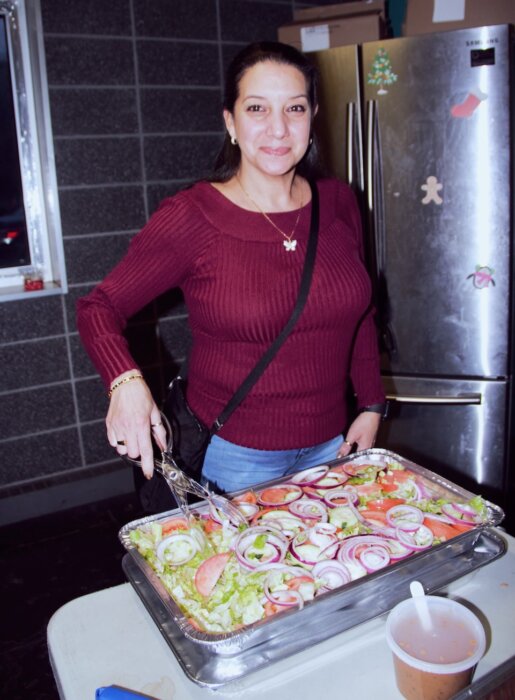 Gloria Rodriguez serves colorful salad at the parade’s re-launch event.
