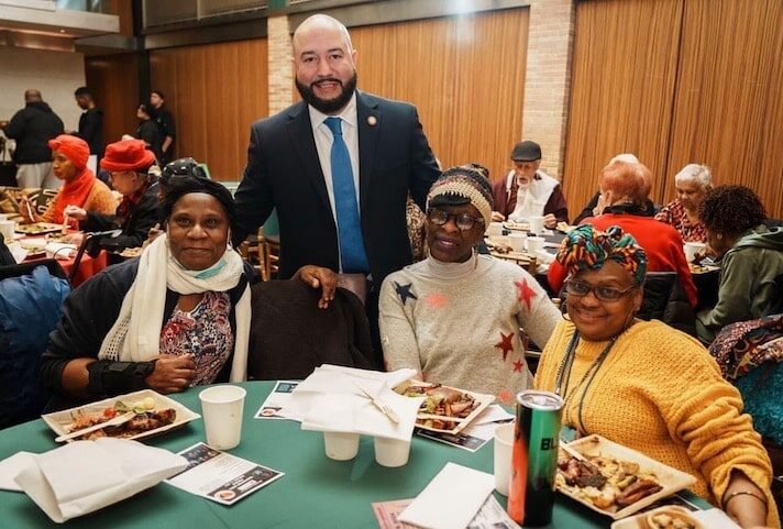 Councilmember Rafael Salamanca poses for a photo with three community members at the Black History Month celebration.
