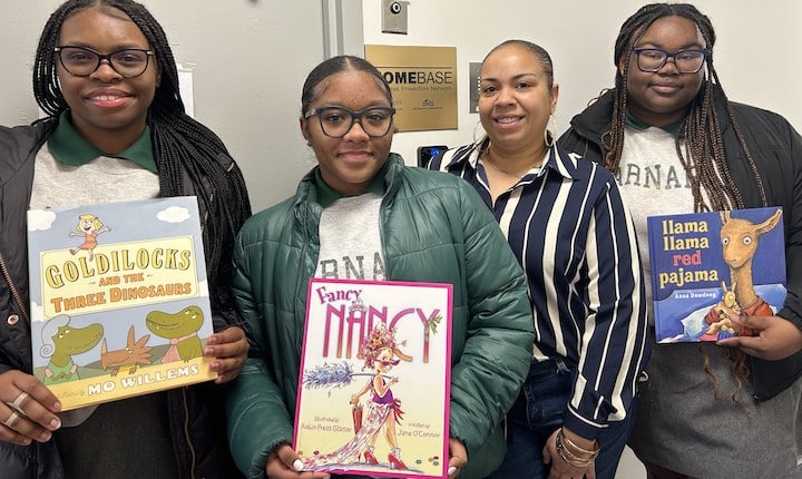 Saint Barnabas High School students pose with a few of the donated childrens' books.