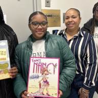 Saint Barnabas High School students pose with a few of the donated childrens' books.