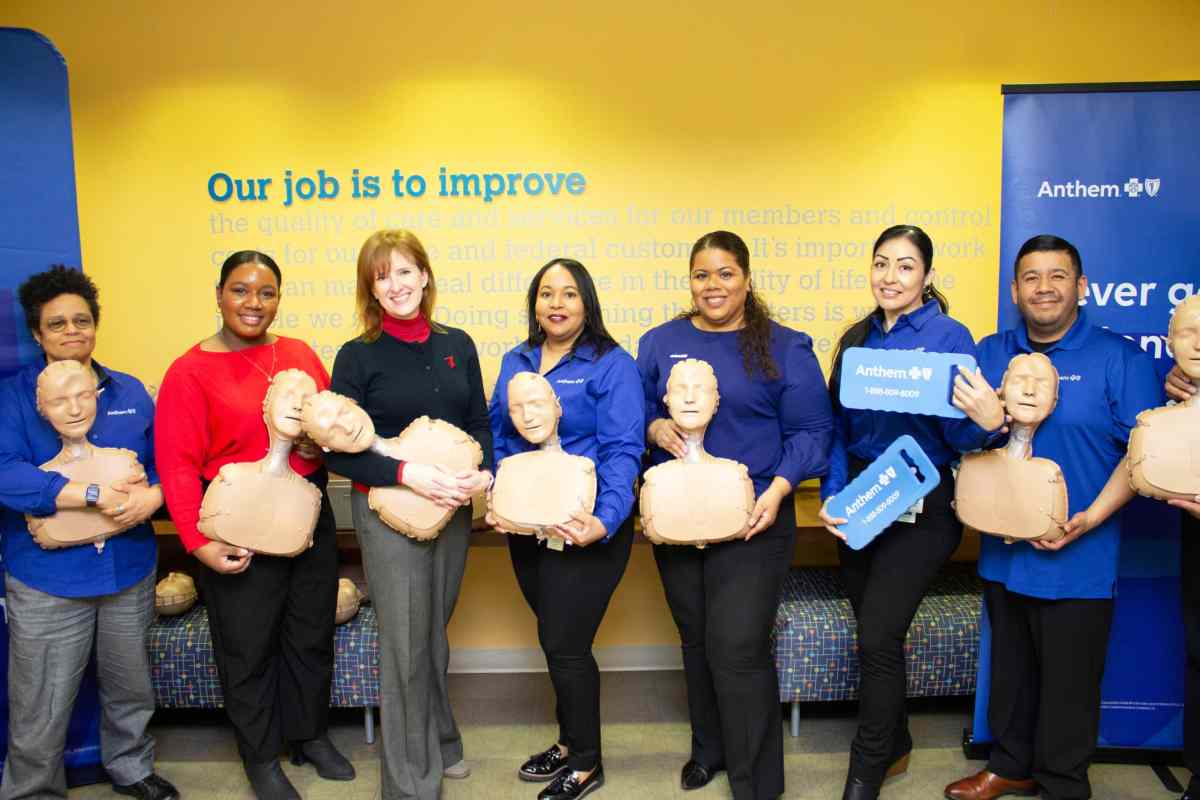 Executives from the various health associations stand together with the mannequins used for CPR training.