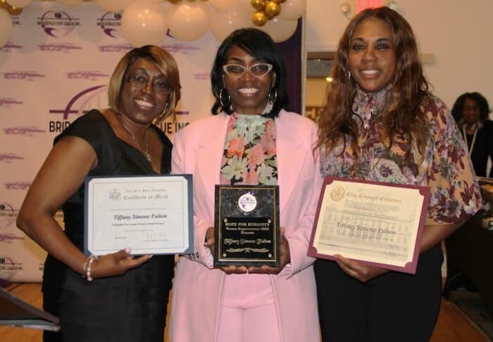 Honoree Tiffany Simone Fulton smiles with her award at the event on March 9.