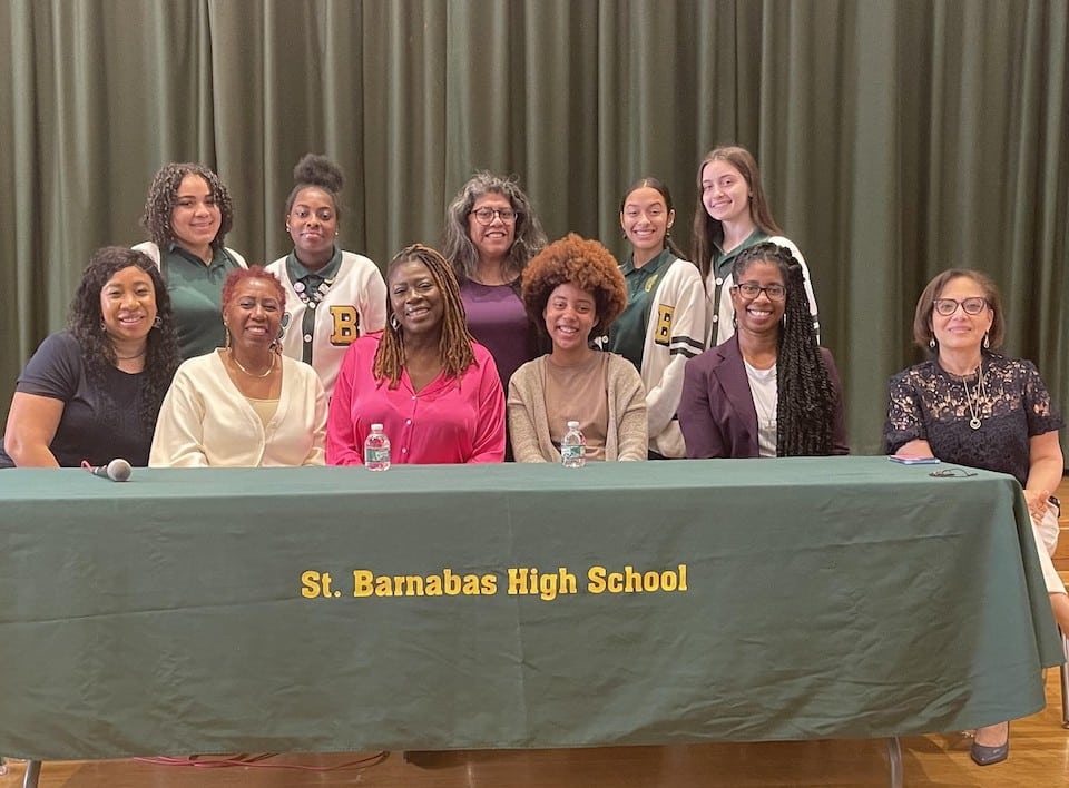 The panelists, interim principal and Saint Barnabas High School students smile at the event.