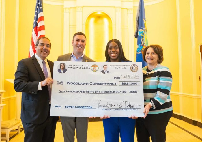 New York City Councilmember Eric Dinowitz and Bronx Borough President Vanessa L. Gibson (middle) pose with a check for $931,000 to the Woodlawn Cemetery and Conservancy.