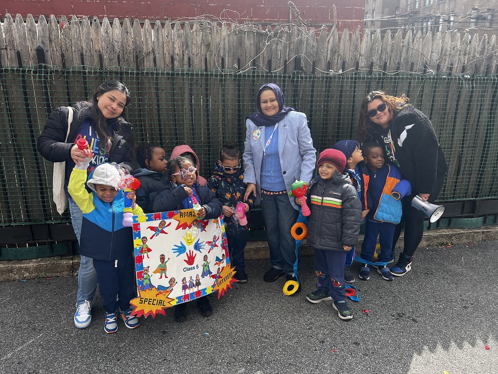 A group poses for a photo with their signs at the Autism Acceptance Parade.