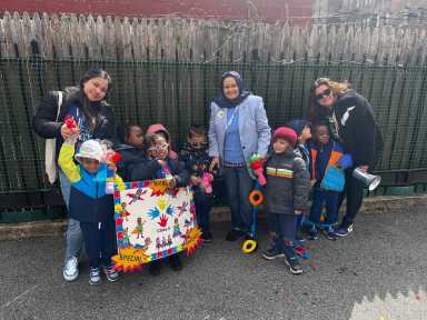 A group poses for a photo with their signs at the Autism Acceptance Parade.