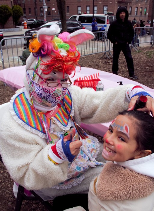 A little girl smiles at the Easter Egg Hunt as she gets her face painted.