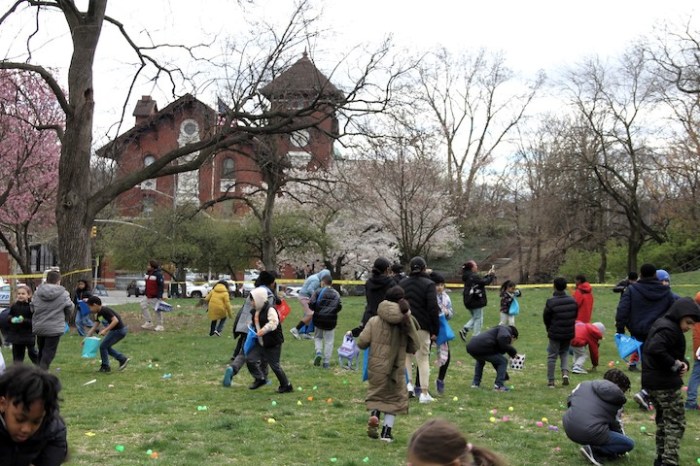 Children hunt for eggs at the Easter Egg Hunt outside the 52nd Precinct on Webster Avenue.