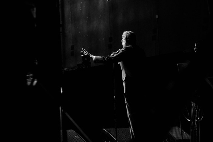 Captured in classic black and white to match a classic voice, John Sterling engages the crowd with an outstretched hand over the Bronx crowd on May 18, 2024.