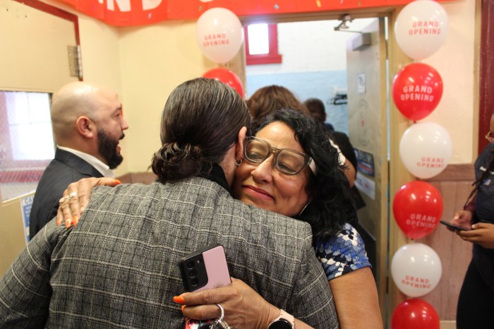 Staff embrace at the ribbon at the ribbon cutting of the new laundry room at the Longwood Academy of Discovery on Friday, May 3, 2024.