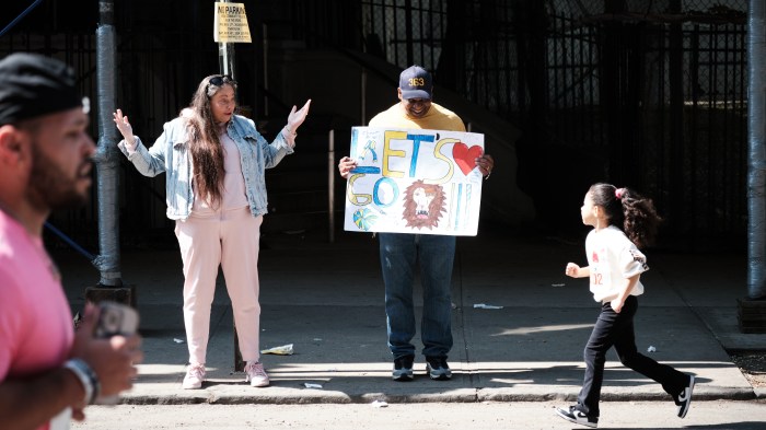 Fireman Velazques Raul holds a sign supporting Middle School 363 during Run The Bronx. He calls the kids "the greatest students in the world." Run the Bronx's goal of improving health, especially heart health, starts young.