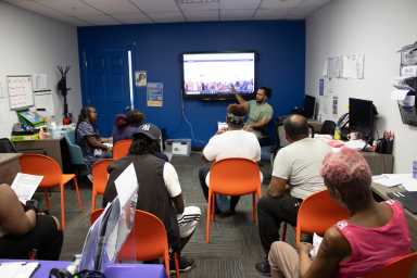 Joel Gil, housing services specialist from Neighbors Together, speaks to attendees about housing vouchers.