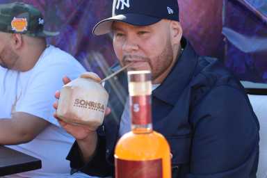 Bronx-born rap star and entrepreneur, Fat Joe, sips on a coconut cocktail at the launch of the newest Puerto Rican rum, Sonrisa, which he partnered with this year.