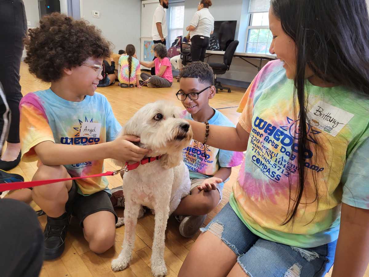Buster, a trained therapy dog, hangs out with new friends, including 10-year-old Angel (left), who said that he now has better skills in dealing with his hyper dog at home.