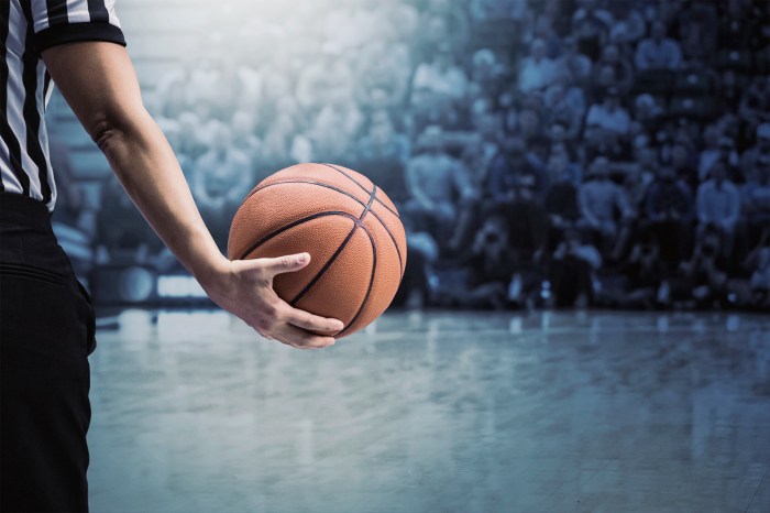 Basketball referee holding ball at a basketball game during a timeout