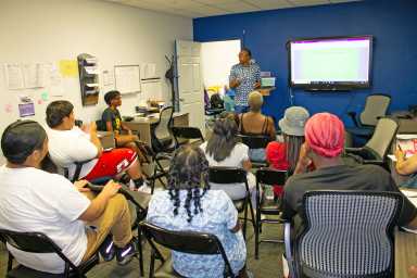 Rachelle Brown speaking to attendees present about the importance of resume and tips on elevating it.