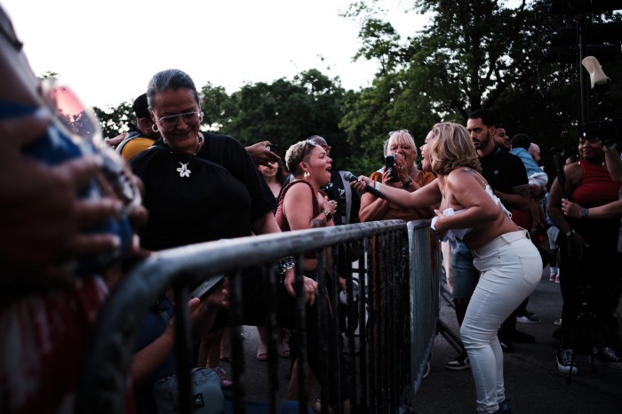 Uptown Royalty singer Jodi Music offers the mic to a fan during on Orchard Beach on June 27, 2024.