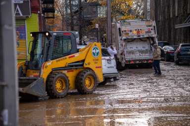 A water main rupture in Bedford Park left streets caked in mud and trash and displaced residents living in ground floor and basement apartments.