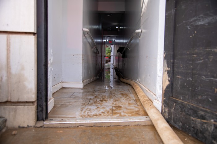 City agencies rallied on Webster Avenue in Bedford Park Tuesday to pump out standing water left in destroyed apartment buildings and businesses after a water main ruptured and flooded the street.