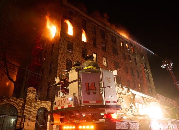 Flames pour from the fifth-floor windows of 2910 Wallace Ave. during a five-alarm apartment fire on Jan. 10, 2025
