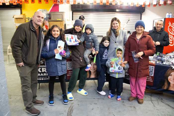 Open Hand Association Food Pantry Founder Aleksander Nilaj (left) Council Member Kristy Marmorato (fourth from right) and her daughter (fifth from right) with a family after receiving their gifts of choice.