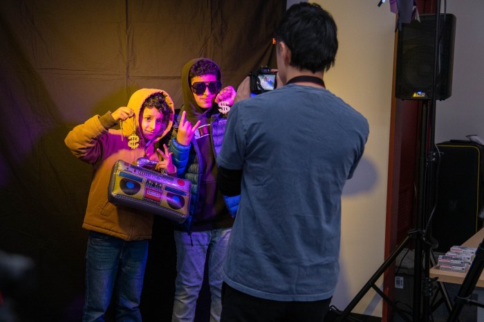Kids and teens posed with their friends at the photo booth, wearing silly accessories and goofing around. Then the library printed the photos for teens to take home.