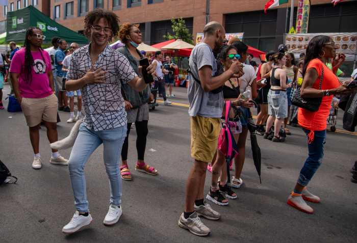 A festival goer dances to the Latin Urbano performance of Annie RR as the weather cooled and Bronxites filled the festival streets to dance and party, Saturday.