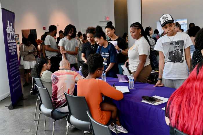 Bronx authors of "The Bronx Writes Back: The Cradle to Prison Pipeline" sign copies of their new book, a collection of stories, poems, essays and original artwork about the impact of systems that divert young people of color into prisons.