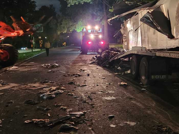 The New York City Department of Sanitation coordinated a multi team operation to dismantle an abandoned trash-filled trailer that had been badly wrecked on the Hutchinson River Parkway. It used heavy machinery to rip off portions of the trailer and haul away the piles of garbage inside of it.