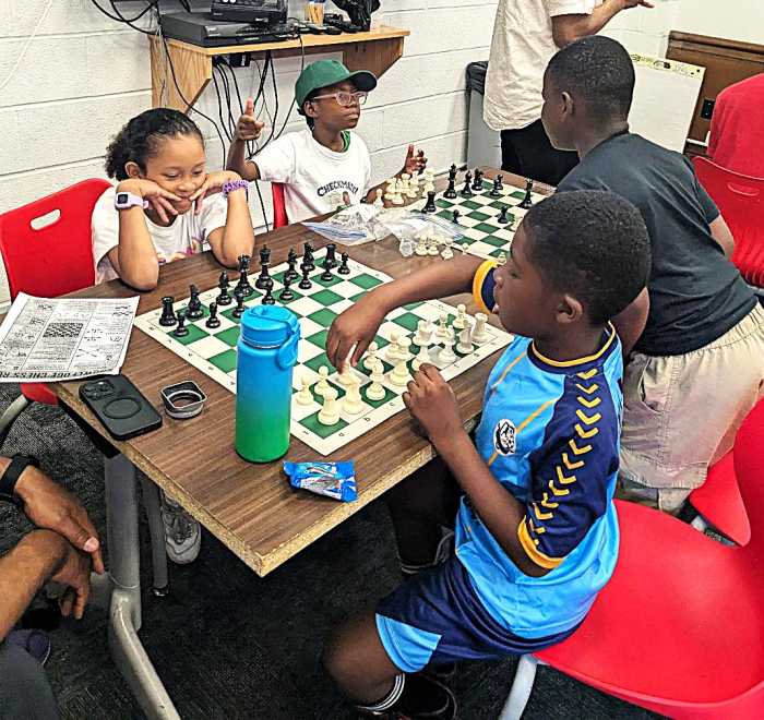 group of students playing chess as part of young kings program