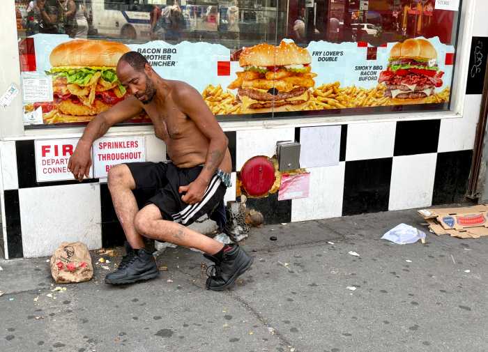 A man was hunched over against the facade of a Checkers for several hours during the hottest hours of the day in July at the Hub, known for its open air drug use in the South Bronx.