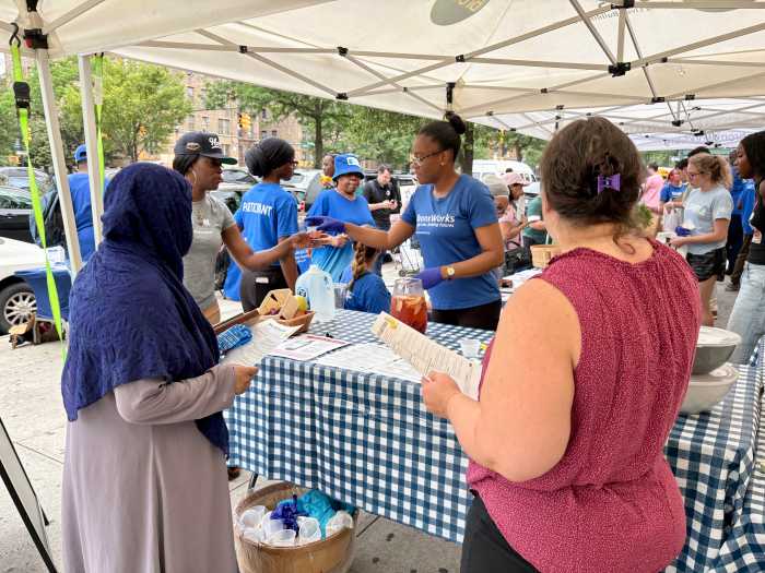 Kalafa Mccalafa hands out samples of water infused with apples and cherries along with recipe sheets for additional infusions. 