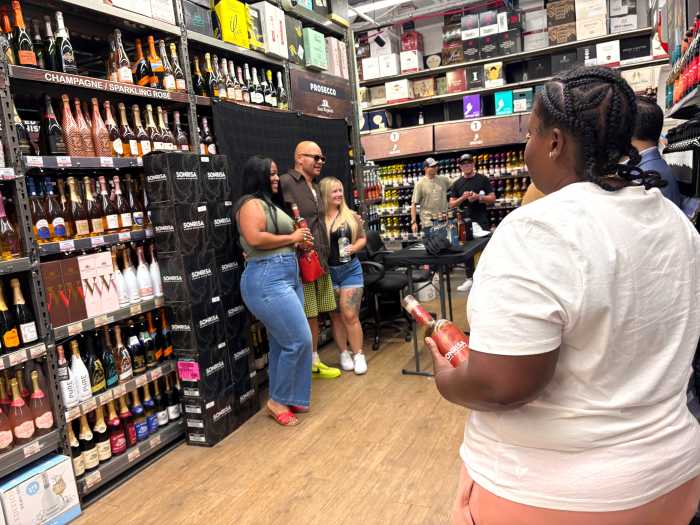 Friends Heather Perez (Left) and Stephanie Beeco (Right) pose with Grammy-nominated hip hop artist Fat Joe (Center) as they purchase autographed bottles of Sonrisa rum from a tasting event Tuesday.