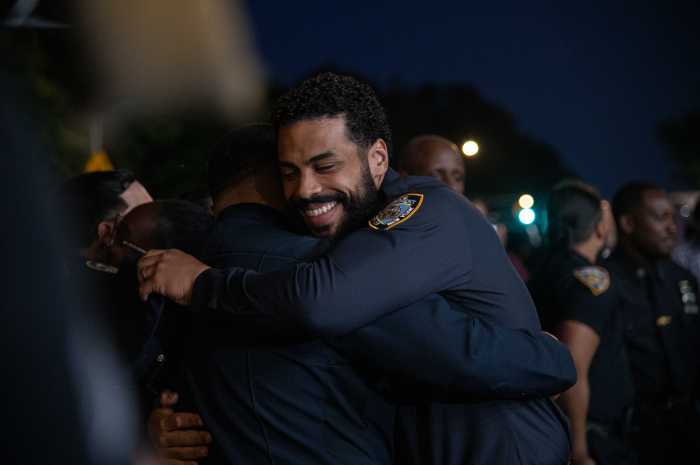 Two NYPD officers hug each other following the closing prayer at Friday's memorial service to Detective Didarul Islam.