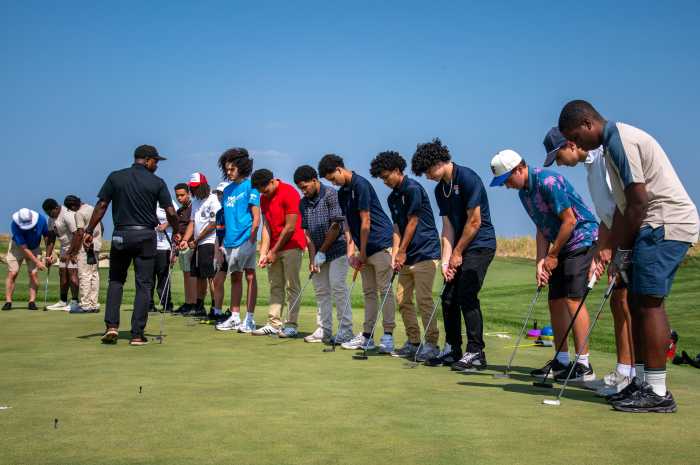 the Advocates Professional Golf Association Director of Player Development, Montrele Wells, who played professional golf for over 10 seasons, lined up the junior players in his group to show them a proper stance and check their grip.