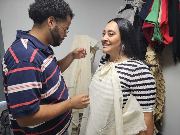 Bronx designer with woman on fitting a dress for a fashion show