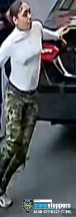 Individual #1 of robbery running past the car wearing a long-sleeve white shirt, green camouflage pants, and white shoes.